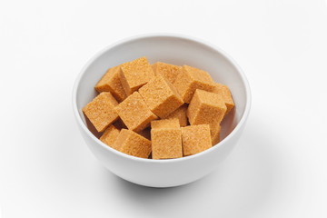 Brown cane sugar cubes isolated on white background