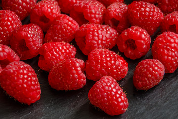 Himbeeren auf schwarzer Schieferplatte