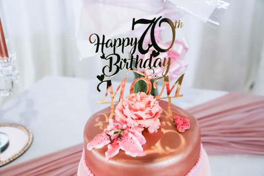 happy 70th birthday mom in rose gold on birthday cake with shoe and handbag fresh flowers
