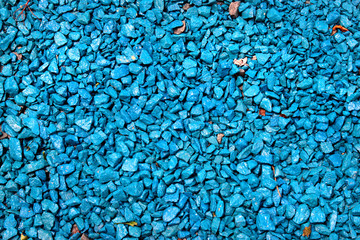 Blue painted gravel in a garden as background