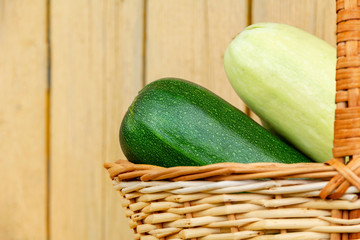 Large fresh zucchini in a wicker basket. Farm harvest of natural vegetables for a healthy meal. rustic wood background