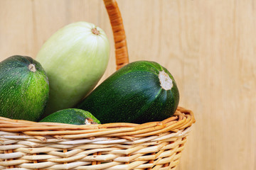 Large fresh zucchini in a wicker basket. Farm harvest of natural vegetables for a healthy meal. rustic wood background