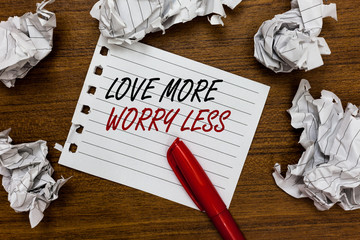 Conceptual hand writing showing Love More Worry Less. Business photo showcasing Have a good attitude motivation be lovable enjoy life Written white page touched red marker scattered paper lump