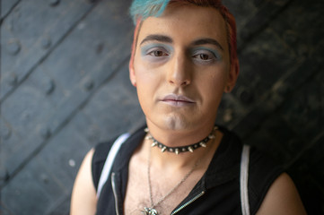Man gay with makeup lifestyle portrait. Transgender man wearing leather collar with spikes