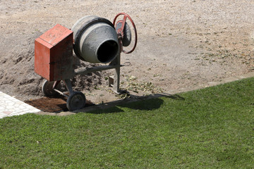 betoniera manuale sul prato del giardino, manual cement mixer on the lawn of the garden