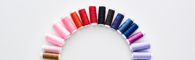 panoramic shot of bright and colorful threads on white background