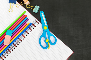 School supplies-notebook, scissors, paper clips, colored pencils on the background of the...