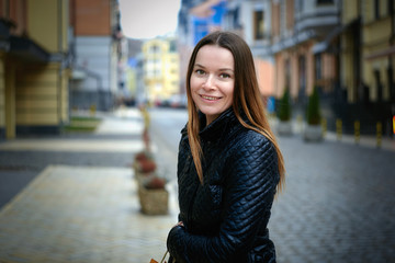 Fototapeta premium happy pretty young woman in casual clothes in cityscape