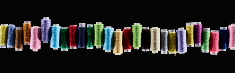 panoramic shot of bright and colorful threads isolated on black