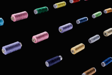 blue, brown, gray, green, pink, purple, yellow threads isolated on black