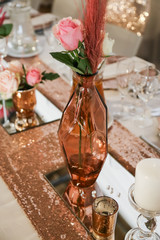 table setting in rose gold with candles and fresh flowers
