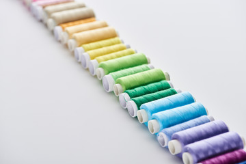 selective focus of bright and colorful threads on white background