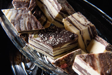 sweets of white and black chocolate on a black background