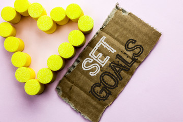 Text sign showing Set Goals. Conceptual photo Target Planning Vision Dreams Goal Idea Aim Target Motivation written Tear Cardboard Piece the plain background with Heart next to it.