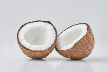 Full coconut and  cracked half on a white background, close up