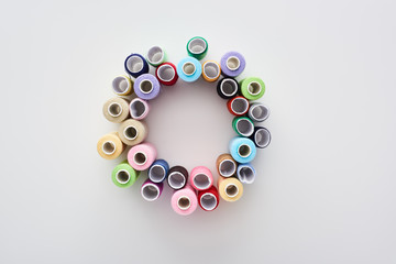 top view of bright and colorful threads on white background