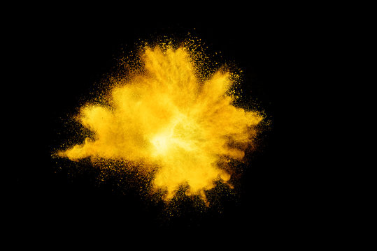Yellow powder explosion on black background.