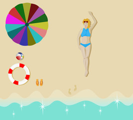 Women in a blue bikini sunbathing on the sand beach with umbrellas, balls, rubber rings and sandals placed beside.