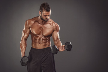 Fototapeta na wymiar Muscular Athletic Men Exercise With Dumbbells