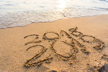 Number 2019 sign on sand beach wave sunset light