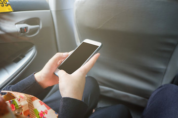 Hand using smartphone in taxi car blank screen