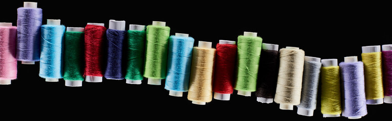 panoramic shot of bright and colorful threads isolated on black