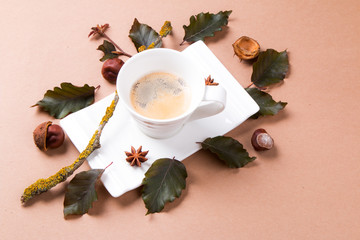 Autumn composition. Cup of coffee and leaves on brown background. Flat lay, top view, copy space Autumn