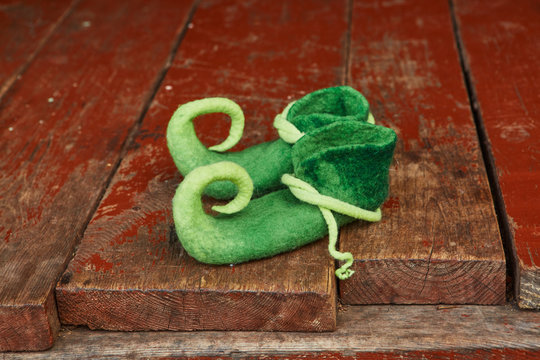 Felted shoes of a fairy-tale character on an old wooden floor.