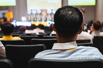 Rear view of Audience reading content in the room or seminar meeting.