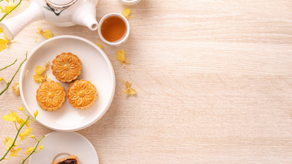 Tasty moon cake for Mid-Autumn festival on bright wooden table, concept of festive afternoon tea...