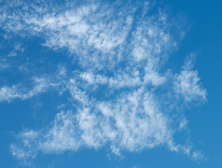 Clouds in the blue sky are similar to "skeleton of a dragon". Mythical concept. Beautiful abstract set on light backdrop.