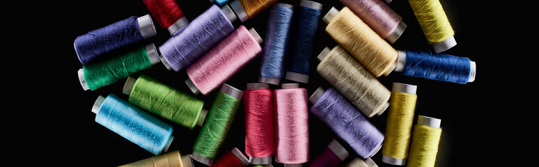 panoramic shot of bright and colorful threads isolated on black