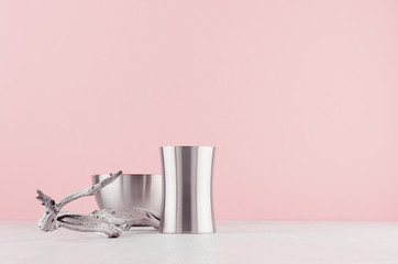 Trendy stylish home decor  with elegant silver polished abstract decoration and old shabby snag on white wood shelf and soft light pink background.