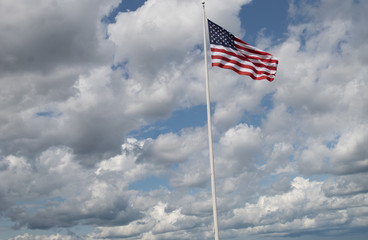 american flag waving in the wind against blue sky