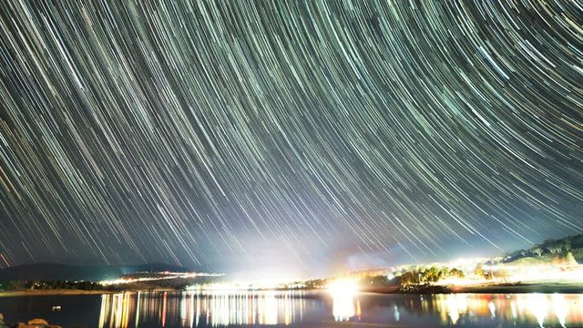 Starry star trail timelapse over Lake Jindabyne looking towards Jindabyne