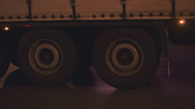Close-up of the tractor wheels in motion on the track. Cool footage. Night transport.