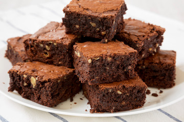 Homemade chocolate brownies on a white plate, side view. Close-up.