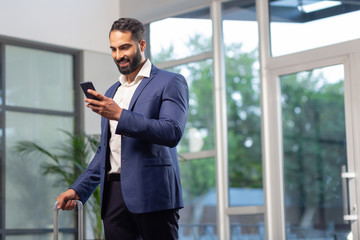 Cheerful bearded office worker having business trip