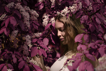 lose up Portrait of a beautiful girl among spring foliage and flowers