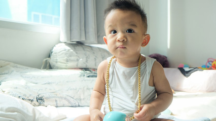 Rich infant baby boy with gold necklace ornament decoration - Powered by Adobe