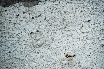Texture of an old cracked concrete wall. Background image of a worn gray concrete surface