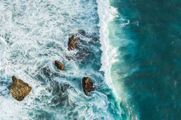 Aerial view of crashing waves on rocks. View from above, drone photo, beautiful nature background