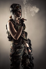 woman in uniform with guns rests smoking cigar