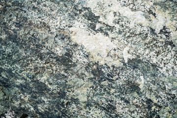 The texture of the stone overgrown with moss. Background image of a boulder