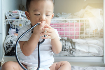 Obraz na płótnie Canvas Infant baby boy playing with stethoscope