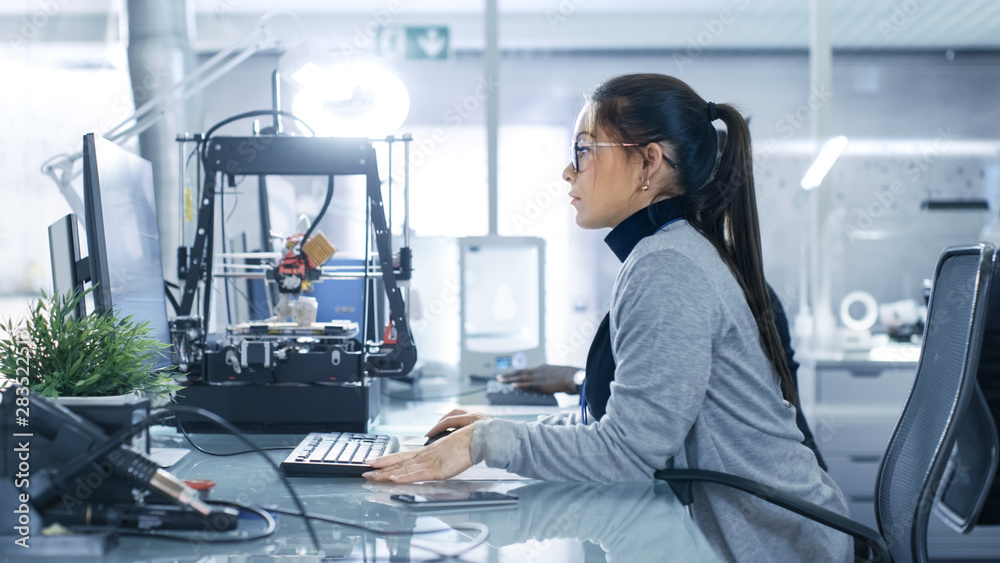 Wall mural white female is working on a computer in a modern high-tech laboratory.