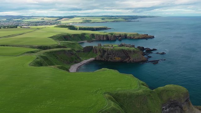 Aerial view of Dunnottar Castle, ruined medieval cliff top fortress located upon rocky headland protruding from sea - panorama of Scotland from above, United Kingdom, Great Britain, Europe
