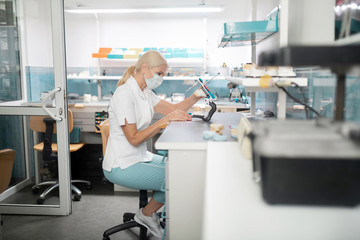 Dental technician working on cast model of teeth.