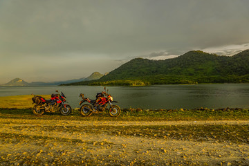 Fototapeta premium Purwakarta, West Java, Indonesia (03/30/2018) : The rider is touring with his motorcycle through the Jatiluhur Dam side which is commonly called Parang Gombong