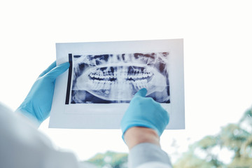 Dentist consulting with patient presenting results on Dental x-ray film About the problem of the patient